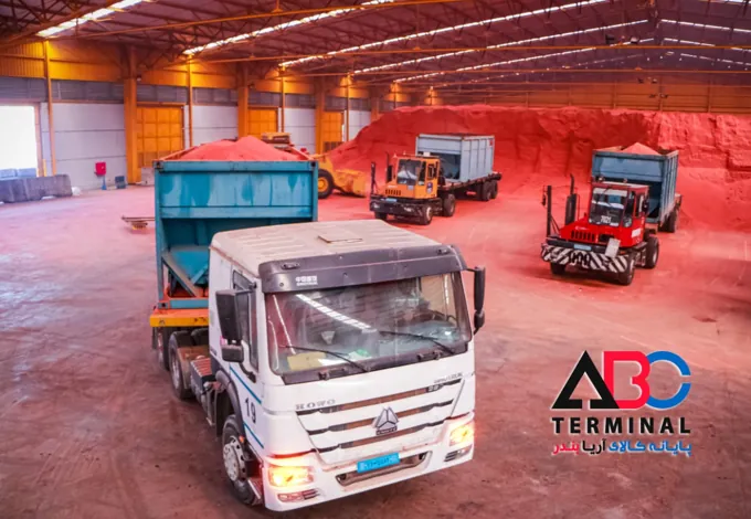 Trucks and loaders moving bulk cargo inside a warehouse