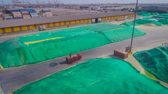 Covered bulk cargo stockpiles across the terminal yard