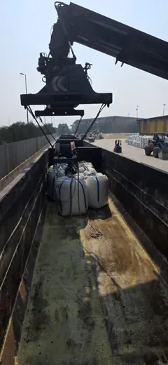 Jumbo bags being handled inside an open rail wagon
